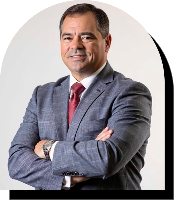 Professional man in a gray suit with arms crossed, smiling confidently.